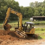 Escavatore Caterpillar a noleggio CGTE durante lavoro di scavo per opere di cura del verde