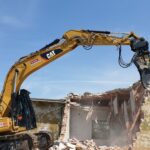 Escavatore CAT con pinza da demolizione a noleggio
